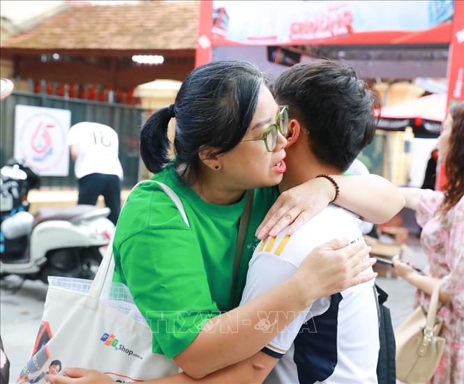 Phụ huynh chia sẻ cảm xúc với thí sinh sau khi hoàn thành ngày thi đầu tiên tại điểm thi Trường THPT Trần Phú - Hoàn Kiếm (phường Cửa Nam). Ảnh: Khánh Hoà - TTXVN