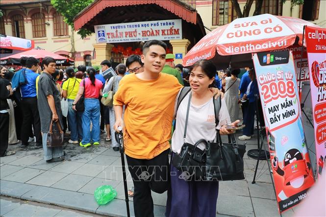Phụ huynh chia sẻ cảm xúc với thí sinh sau khi hoàn thành ngày thi đầu tiên tại điểm thi Trường THPT Trần Phú - Hoàn Kiếm (phường Cửa Nam). Ảnh: Khánh Hoà - TTXVN