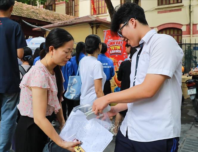 Phụ huynh chia sẻ cảm xúc với thí sinh sau khi hoàn thành ngày thi đầu tiên tại điểm thi trường THPT Trần Phú - Hoàn Kiếm (phường Cửa Nam). Ảnh: Khánh Hoà - TTXVN