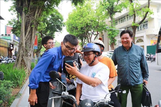 Phụ huynh chia sẻ cảm xúc với thí sinh sau khi hoàn thành ngày thi đầu tiên tại điểm thi trường THPT Trần Phú - Hoàn Kiếm (phường Cửa Nam). Ảnh: Khánh Hoà - TTXVN