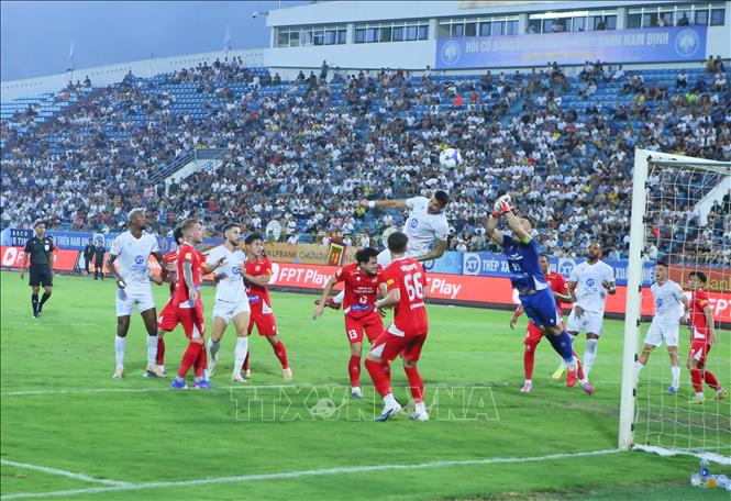 Tình huống tranh chấp bóng giữa cầu thủ Thép Xanh Nam Định (áo trắng) và các cầu thủ Công an TP. Hồ Chí Minh. Ảnh: Công Luật - TTXVN