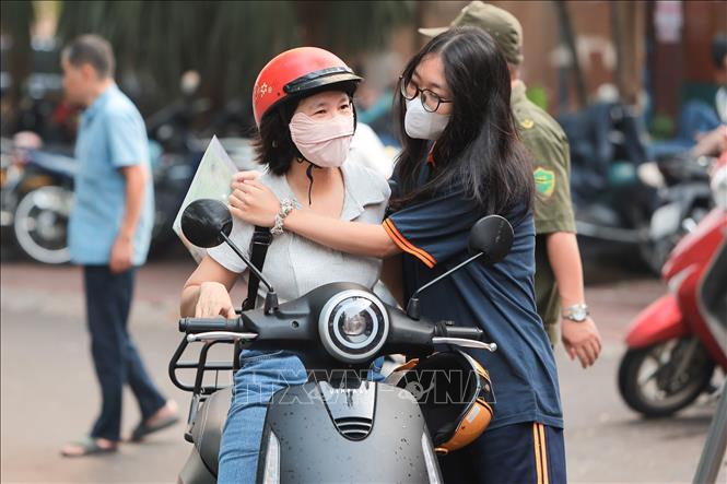 Động viên con trước khi bước vào phòng thi tại điểm thi Trường THCS Giảng Võ (phường Giảng Võ). Ảnh: Lê Đông - TTXVN