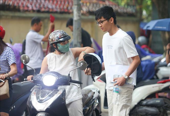 Phụ huynh đưa thí sinh tới điểm thi Trường THPT Cầu Giấy để thi môn cuối. Ảnh: Bùi Tiến Long/TTXVN phát