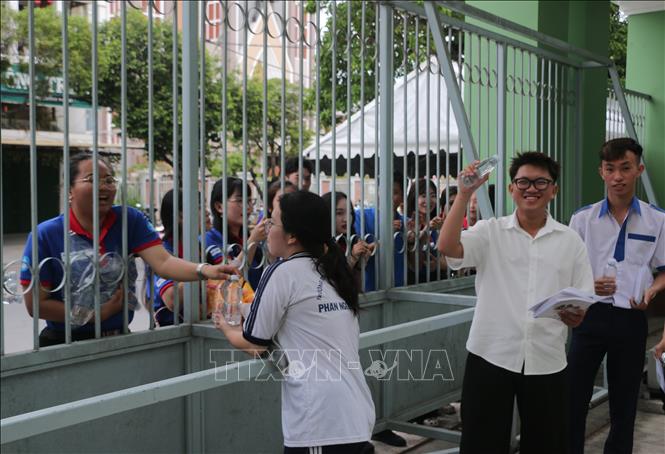 Lực lượng tình nguyện tiếp sức mùa thi hỗ trợ nước uống và bánh ngọt co các thí sinh. Ảnh: Tuấn Kiệt – TTXVN