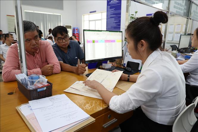 Cán bộ Chi nhánh Văn phòng đăng ký đất đai phường Dĩ An (Thành phố Hồ Chí Minh) giải quyết thủ tục đất đai cho người dân. Ảnh: Hồng Đạt - TTXVN