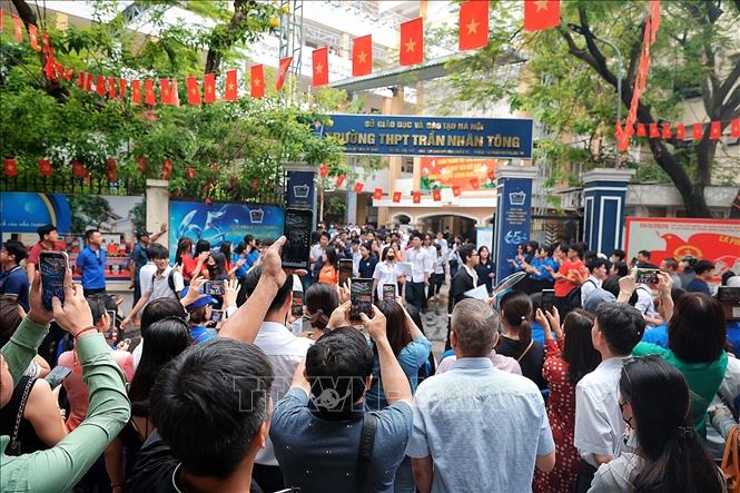 Các phụ huynh nhanh tay ghi lại khoảnh khắc các sĩ tử của mình hoàn thành môn thi cuối cùng của Kỳ thi tốt nghiệp THPT. Ảnh: Phạm Tuấn Anh - TTXVN