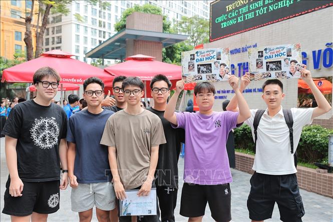 Nhóm bạn giơ cao tấm bảng mang thông điệp “Chúc mừng thi đỗ đại học” để đón và chúc mừng người thân sau khi hoàn thành ngày thi cuối cùng của Kỳ thi tốt nghiệp THPT năm 2026 tại điểm thi Trường THCS Giảng Võ (phường Giảng Võ, Hà Nội). Ảnh: Lê Đông - TTXVN