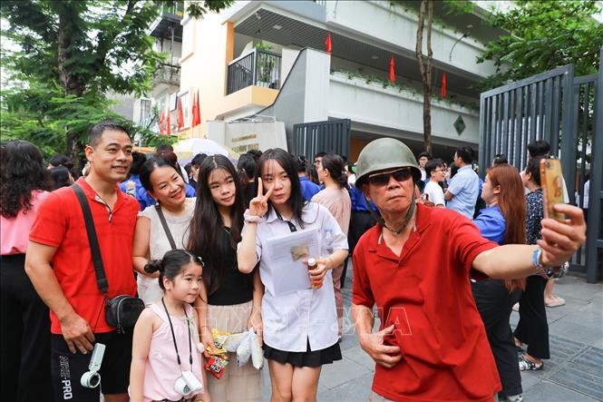 Phụ huynh chia sẻ cảm xúc với thí sinh sau khi hoàn thành Kỳ thi tốt nghiệp THPT 2026 tại điểm thi Trường THPT Trần Phú - Hoàn Kiếm (phường Cửa Nam). Ảnh: Khánh Hoà - TTXVN
