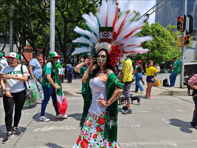 Một phụ nữ hóa trang với trang phục mang màu sắc quốc kỳ Mexico trên đại lộ Paseo de la Reforma trong ngày khai mạc World Cup 2026. Ảnh: Phương Lan - PV TTXVN tại Mexico 