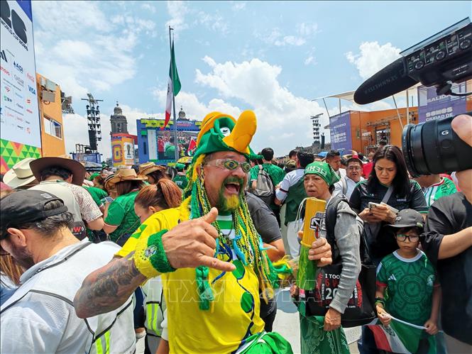 Cổ động viên tuyển Brazil mang theo quốc kỳ và áo đấu đội tuyển, hòa mình vào không khí lễ hội bóng đá tại Zócalo. Ảnh: Phương Lan - PV TTXVN tại Mexico 