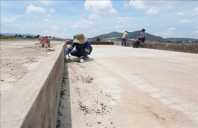 Nhóm công nhân hoàn thiện một đoạn khung modul để chuẩn bị lắp đặt khung thép trước khi đổ bê tông xi măng lớp M350 trên đường cất hạ cánh của sân bay Liên Khương. Ảnh: Nguyễn Dũng – TTXVN 
