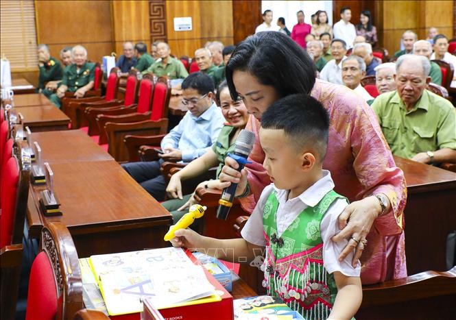 Phó Chủ tịch Quốc hội Nguyễn Thị Thanh trao quà và hướng dẫn học sinh tiểu học sử dụng Bút chấm đọc Tiếng Anh. Ảnh: Xuân Tư - TTXVN