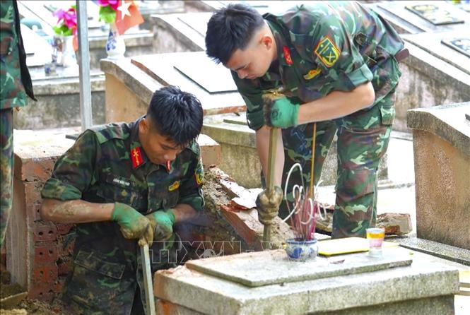 Dù điều kiện khai quật khó khăn, nhiều phần mộ có độ sâu lớn, cán bộ, chiến sĩ vẫn cẩn trọng bóc tách từng lớp đất để tìm kiếm và thu thập mẫu phẩm phục vụ giám định. Ảnh: TTXVN phát
