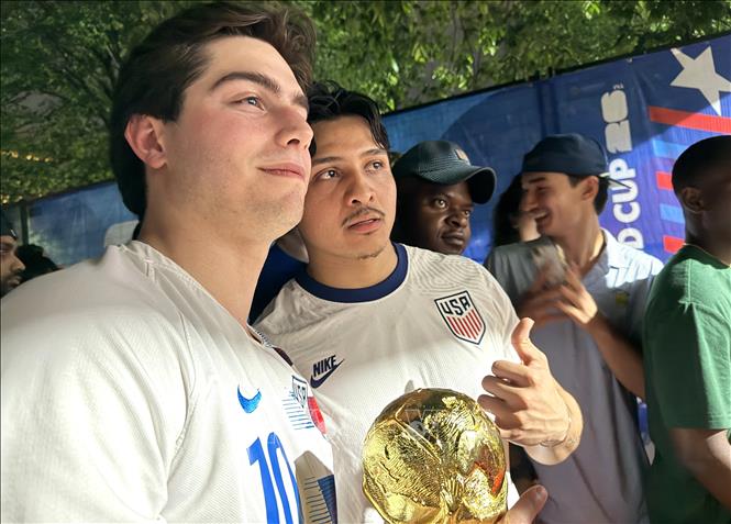 Cổ động viên Mỹ hào hứng cầm mô hình Cúp Vàng FIFA World Cup tại khu Fan Zone. Ảnh: Ngọc Quang - PV TTXVN tại Mỹ
