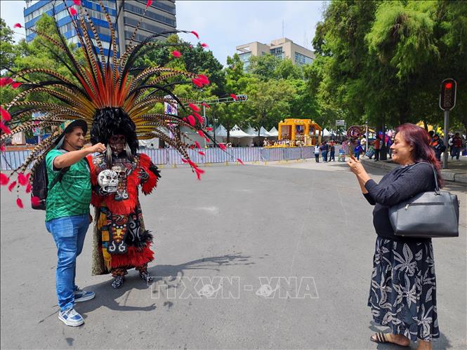 Người dân và du khách lưu giữ những khoảnh khắc đáng nhớ tại lễ diễu hành văn hóa ở Mexico City. Ảnh: Phương Lan - PV TTXVN tại Mexico 