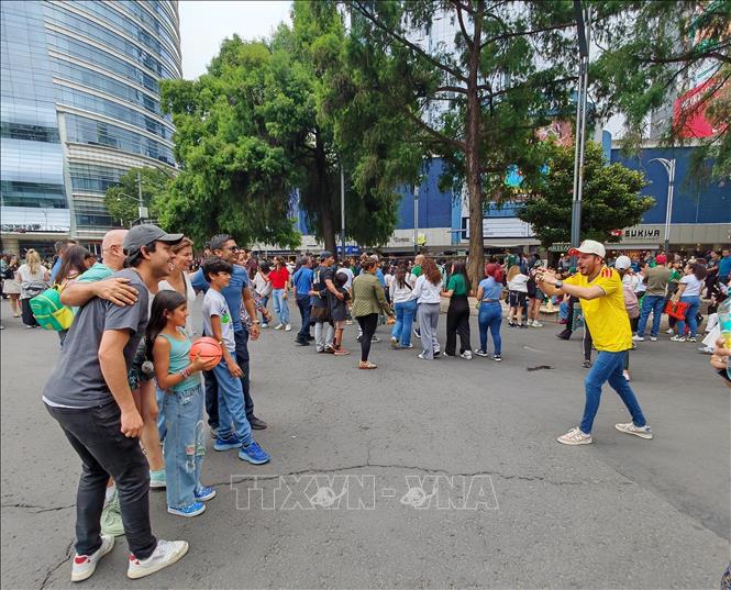 Du khách quốc tế chụp ảnh lưu niệm tại cuộc diễu hành văn hóa chào mừng World Cup 2026 ở Mexico City ngày 13/6. Ảnh: Phương Lan - PV TTXVN tại Mexico 