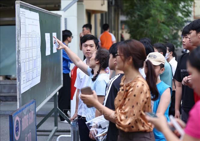 Phụ huynh cùng thí sinh xem sơ đồ bố trí phòng thi. Ảnh: Thanh Tùng - TTXVN 