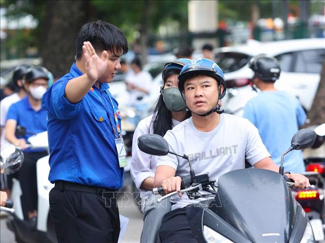 Các tình nguyện viên hướng dẫn phụ huynh và thí sinh vào khu vực thi. Ảnh: Bùi Tiến Long - TTXVN phát