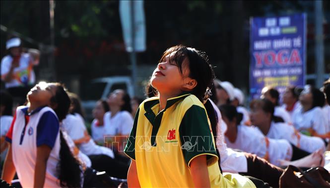Một bạn trẻ hướng mình về phía ánh nắng mai trong tư thế Cobra. Ảnh: Nguyễn Hằng - TTXVN