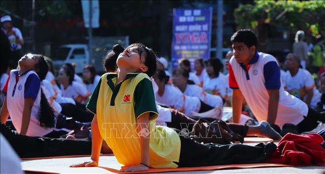 Một bạn trẻ hướng mình về phía ánh nắng mai trong tư thế Cobra. Ảnh: Nguyễn Hằng - TTXVN
