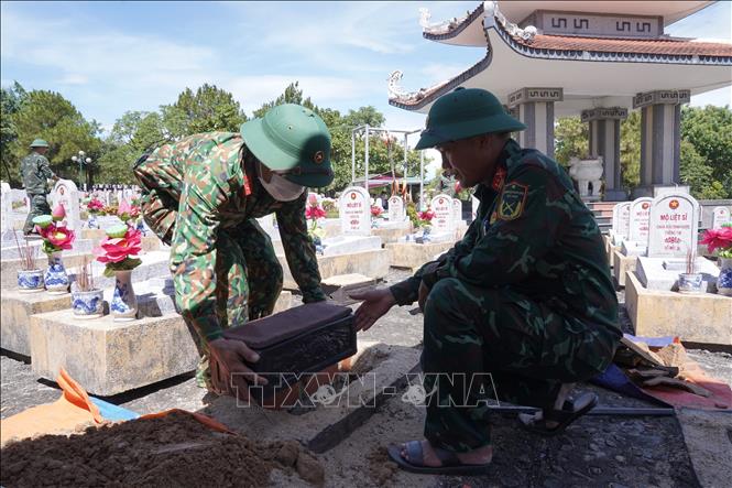 Sau khi các cán bộ y tế hoàn thành lấy mẫu, hài cốt được gói buộc cẩn thận, cho vào tiểu và đưa về lại vị trí cũ, thực hiện công tác hoàn mộ. Ảnh: Thanh Thuỷ-TTXVN                               
