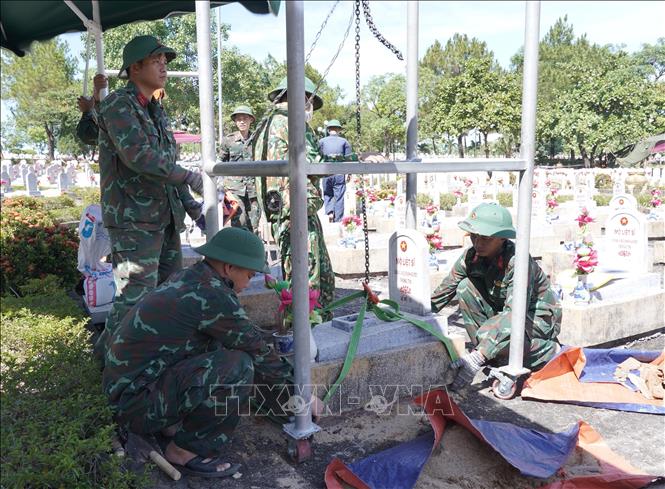 Đội 584, Phòng chính trị, Bộ Chỉ huy Quân sự tỉnh Quảng Trị dùng ròng rọc tự chế nâng mộ lên để phục vụ công tác lấy mẫu ADN. Ảnh: Thanh Thuỷ-TTXVN                                                             