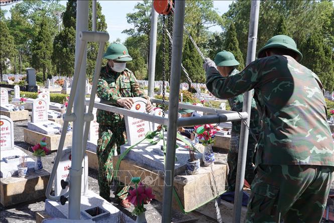 Đội 584, Phòng chính trị, Bộ Chỉ huy Quân sự tỉnh Quảng Trị dùng ròng rọc tự chế nâng mộ lên để phục vụ công tác lấy mẫu ADN. Ảnh: Thanh Thuỷ-TTXVN                                                             
