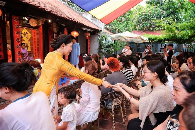 Nghệ nhân phát thẻ cho khản giả xem tại Bích Câu Đạo Quán. Ảnh: Phạm Tuấn Anh - TTXVN