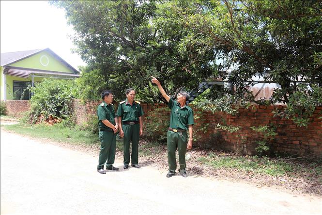 Cựu chiến binh Hán Vinh Hà (ngoài cùng bên phải) chia sẻ về con đường gia đình đã hiến đất và đóng góp kinh phí để xây dựng, kiên cố hóa. Ảnh: Hoài Thu – TTXVN