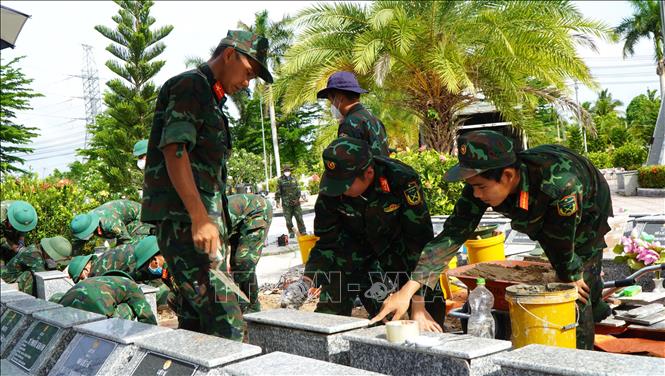 Sau khi hoàn thành công tác lấy mẫu hài cốt liệt sĩ, lực lượng chức năng tiến hành xây dựng lại mộ như hiện trạng ban đầu. Ảnh: Nhựt An - TTXVN