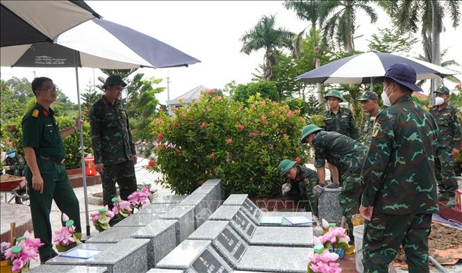 Sau khi hoàn thành công tác lấy mẫu hài cốt liệt sĩ, lực lượng chức năng tiến hành xây dựng lại mộ như hiện trạng ban đầu. Ảnh: Nhựt An - TTXVN