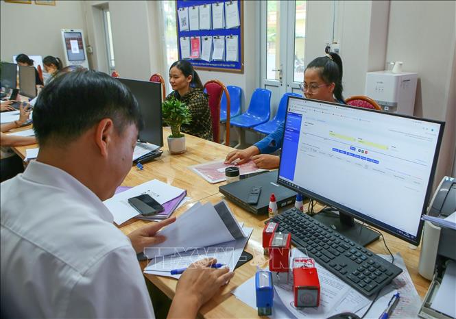 Cán bộ Trung tâm Phục vụ hành chính công phường Thành Nam giải quyết thủ tục cho người dân. Ảnh: Công Luật - TTXVN