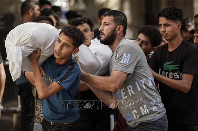 Người dân Palestine chuyển thi thể nạn nhân thiệt mạng trong vụ không kích của Israel, tại bệnh viện Al-Shifa ở thành phố Gaza, ngày 14/6/2026. Ảnh: THX/TTXVN