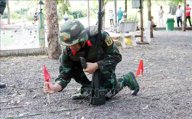 Lực lượng công binh triển khai công tác dò tìm, làm sạch thiết bị, vật liệu nổ tại khu vực khảo sát, thăm dò hài cốt liệt sĩ. Ảnh: Xuân Khu-TTXVN