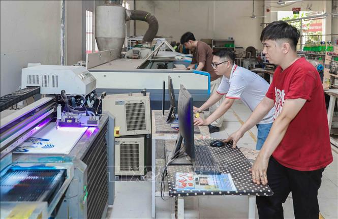 Máy in UV tại công ty TNHH Nam Bình được sử dụng để in tự động và phát triển mẫu, là một trong những công nghệ hiện đại nhất Việt Nam. Hệ thống này được ứng dụng trực tiếp vào dây chuyền may giày nhằm nâng cao chất lượng và năng suất. Ảnh: Phan Phương – TTXVN