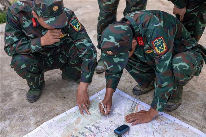 Các thành viên trong đội xác minh thông tin về sơ đồ vực mộ chí liệt sĩ (được thân nhân liệt sĩ cung cấp) tại hiện trường, mong sớm đưa “đồng đội” về với gia đình, quê hương. Ảnh: Hoàng Hiếu - TTXVN