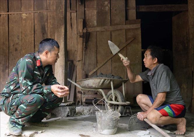 Trung tá Hoàng Vũ Dũng - Đội phó Đội tìm kiếm, quy tập hài cốt liệt sĩ Tuyên Quang xác minh, đối chiếu thông tin về nơi chôn cất 12 liệt sĩ được cung cấp với người dân thôn Hoàng Lỳ Phả, xã Minh Tân. Ảnh: Hoàng Hiếu - TTXVN