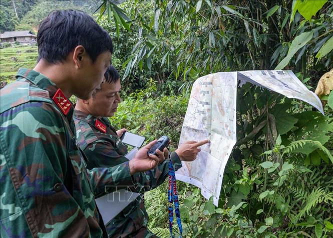 Trung tá Hoàng Vũ Dũng - Đội phó Đội tìm kiếm, quy tập hài cốt liệt sĩ Tuyên Quang và Đại uý Triệu Văn Vương so sánh bản đồ với thông tin được cung cấp. Ảnh: Hoàng Hiếu - TTXVN