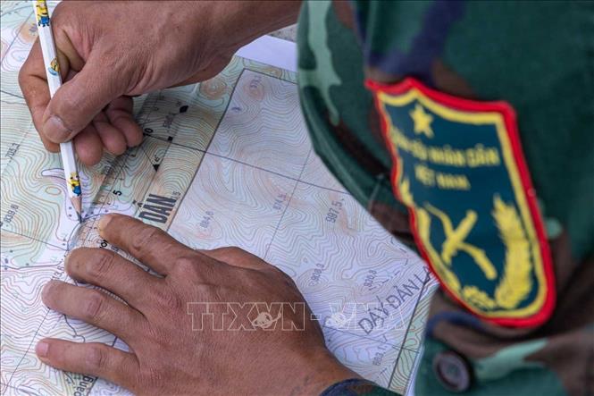 Xác minh thông tin được cung cấp với thực địa trên bản đồ. Ảnh: Hoàng Hiếu - TTXVN