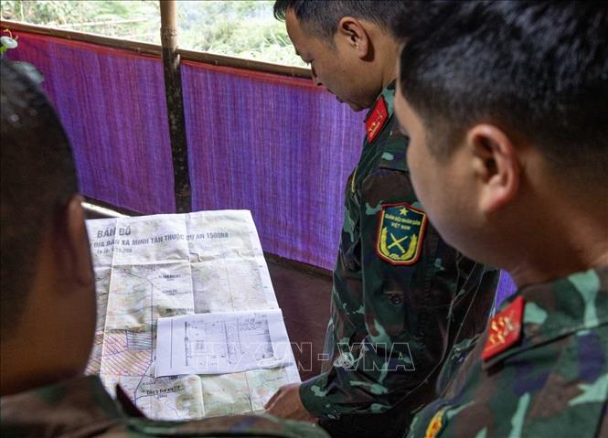 So sánh, đối chiếu bản đồ với sơ đồ mộ phần liệt sĩ hy sinh tại xã Minh Tân được thân nhân liệt sĩ cung cấp. Ảnh: Hoàng Hiếu - TTXVN