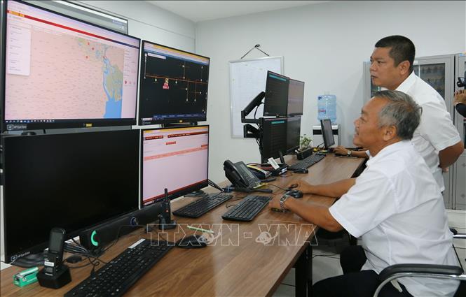 Nhân viên công ty Điện lực Bình Chánh thực hiện giám sát lưới điện trong khu vực. Ảnh: Thanh Vũ – TTXVN