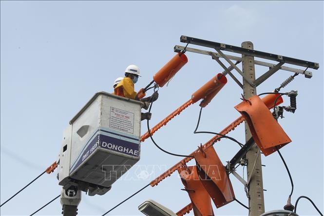 Nhân viên Công ty lưới điện cao thế TP. Hồ Chí Minh sửa chữa điện hotline. Ảnh: Thanh Vũ – TTXVN