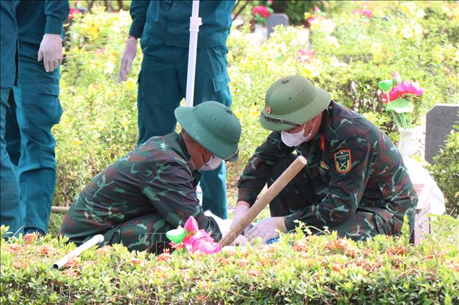 Lấy mẫu hài cốt liệt sĩ tại Nghĩa trang Liệt sĩ thành phố Huế. Ảnh: Mai Trang - TTXVN 
