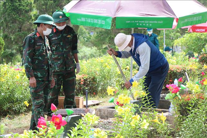 Lấy mẫu hài cốt liệt sĩ tại Nghĩa trang Liệt sĩ thành phố Huế. Ảnh: Mai Trang - TTXVN 
