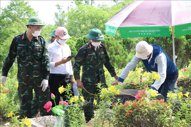 Lấy mẫu hài cốt liệt sĩ tại Nghĩa trang Liệt sĩ thành phố Huế. Ảnh: Mai Trang - TTXVN 