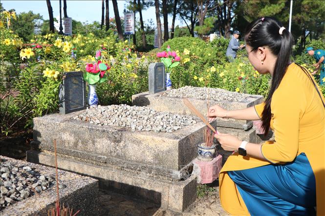 Thắp hương tri ân các phần mộ liệt sĩ tại Nghĩa trang Liệt sĩ thành phố Huế. Ảnh: Mai Trang - TTXVN 