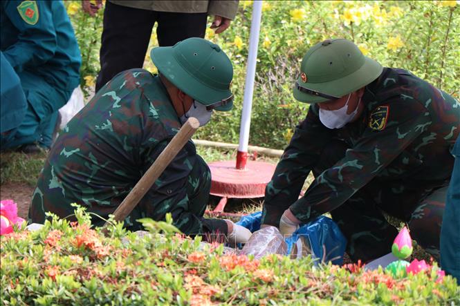 Lấy mẫu hài cốt liệt sĩ tại Nghĩa trang Liệt sĩ thành phố Huế. Ảnh: Mai Trang - TTXVN 