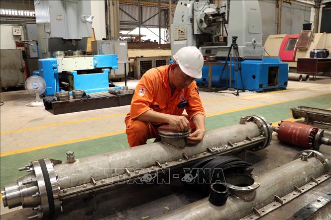 Công nhân Xí nghiệp Cơ điện lắp ráp hộp nối cáp ngầm đơn vị tự chế tạo. Ảnh: Đoàn Mạnh Dương - TTXVN