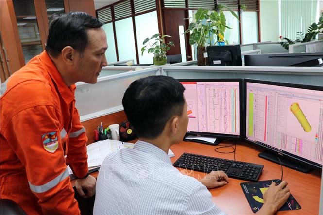 Các kỹ sư Xí nghiệp Địa vật lý giếng khoan theo dõi kết quả tính toán trên Bộ quy trình giải minh Loginter 2.0 đối với thiết bị dưới giếng khoan. Ảnh: Đoàn Mạnh Dương - TTXVN