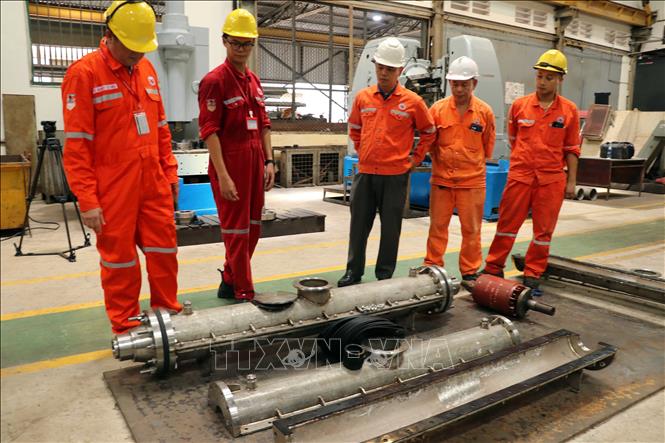 Đội ngũ kỹ sư Xí nghiệp Cơ điện kiểm tra hộp nối cáp ngầm vừa được chế tạo. Ảnh: Đoàn Mạnh Dương - TTXVN
